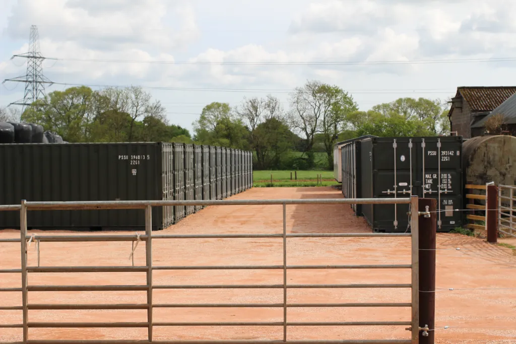 Large gated area with 2 parallel rows of shipping containers